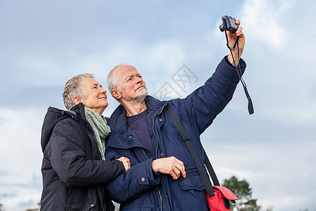 老人夫妇自画肖像老年妻子纪念品回忆闲暇乐趣冒充男人天空自拍背景图片