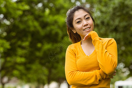 美丽的女人手在公园的下巴上闲暇绿地棕色草地女性橙子头发图片