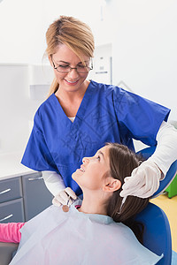 和一个快乐的年轻病人一起微笑儿科牙医斜角镜医疗保健员女孩工作设备考试探索者诊所女士图片