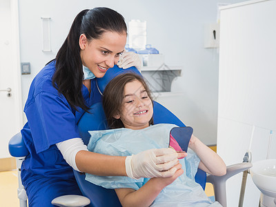 儿科牙医和年轻持有镜像的病人图片