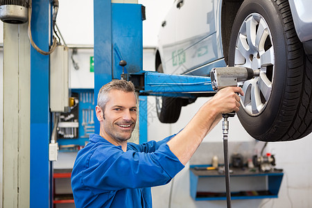 机械调整轮胎轮车轮服务男人工具工人男性微笑车轮轮毂作坊修理图片