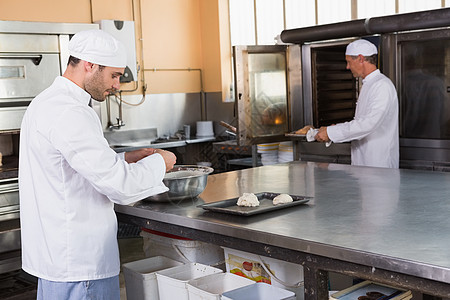 烤面包机在混合碗里做面粉工作专注饮食职业工业店铺餐饮柜台男人厨房图片