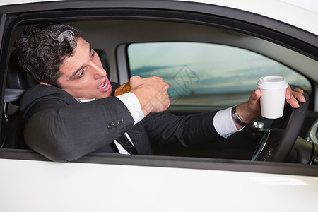 男人在电话上喝咖啡吃甜甜圈驾驶沟通男性人士零售陈列室销售车辆营业员杯子图片
