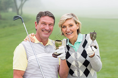 快乐高尔夫夫妇的奖杯时间爱好快乐活动优胜者夫妻男性运动服装假期图片