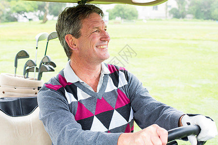 快乐的高尔夫球手驾驶他的高尔夫鼓假期阳光男人运动闲暇休闲运动员老年方向盘高尔夫球图片