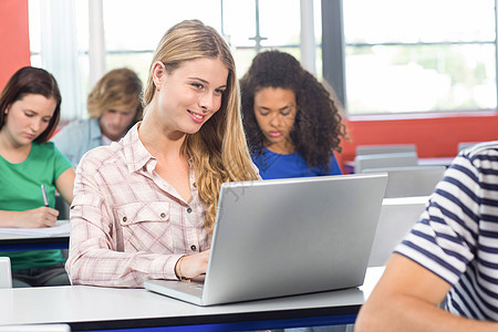 在课堂上使用笔记本电脑的女学生学习男人桌子教育技术高等教育大学生大学课程女孩图片