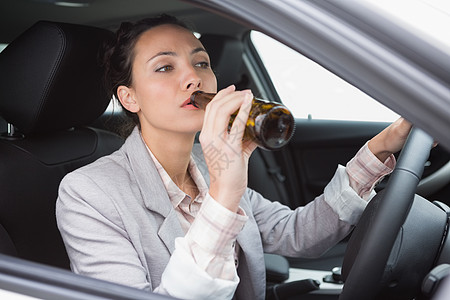 妇女开车时喝啤酒酒后驾车运输啤酒方向盘风险车辆司机闲暇女士零件图片