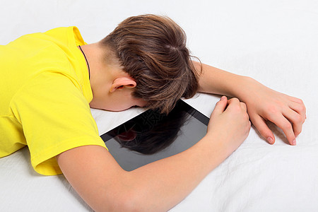 视觉疲劳带平板电脑的疲劳青少年男生房间孩子童年孤独小伙子倦怠少年沙发药片背景