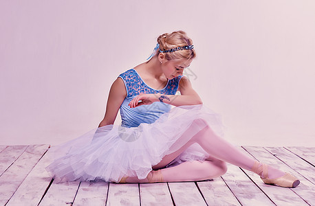 坐在木地板上坐着疲累的芭蕾舞舞蹈者蓝色戏服成人地面工作室舞蹈艺术家女士女性女孩图片