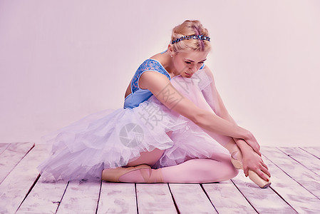 坐在木地板上坐着疲累的芭蕾舞舞蹈者舞蹈家成人裙子冒充工作室女士姿势艺术家女孩舞蹈图片