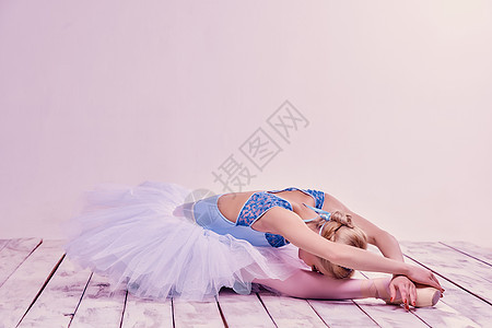 躺在木地板上疲倦的芭蕾舞舞蹈者图片