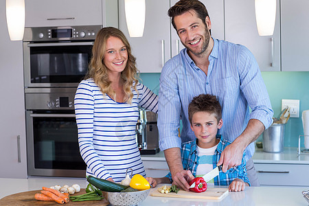 幸福的家庭一起准备蔬菜的蔬菜儿子女士母亲父亲台面柜台素食者女性快乐桌子图片