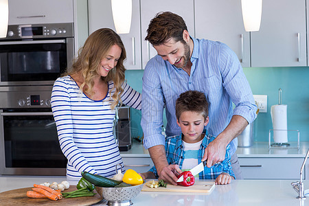 幸福的家庭一起准备蔬菜的蔬菜台面女士闲暇健康饮食厨房桌子孩子儿子服装休闲图片