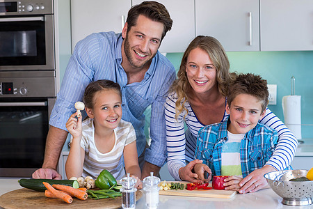 幸福的家庭一起准备蔬菜的蔬菜健康饮食切菜板木板母亲住所柜台厨房女孩男性女士图片