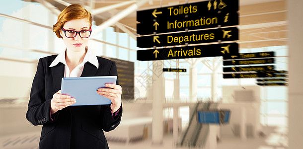 红头女商务人士使用平板电脑的复合图像触摸屏职业航空商务眼镜专注数字航班女性飞机场图片