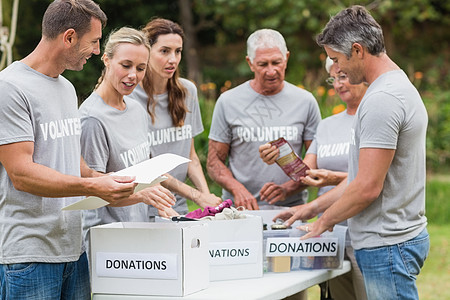 看着捐赠箱的志愿者们快乐女士闲暇娱乐晴天社区志愿女性组织阳光福利图片
