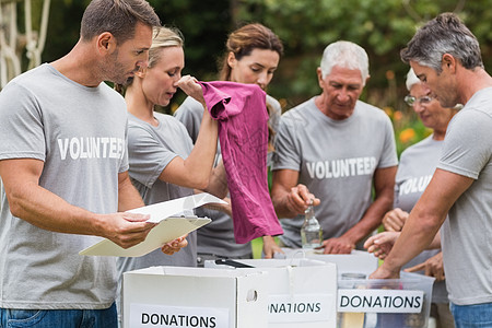 看着捐赠箱的志愿者们快乐农村志愿闲暇男性老年阳光志愿者晴天盒子环境图片