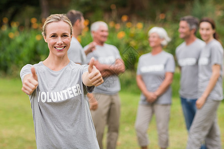 带着拇指的快乐志愿者微笑道德团体志愿老年男人社区团队服务女士图片