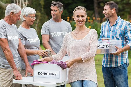 快乐的志愿者家庭将捐赠物品分离开来志愿老年盒子福利娱乐阳光女性女士活动男性图片