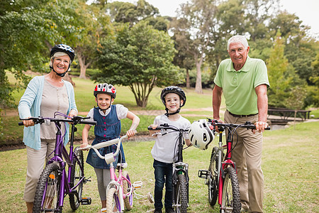 祖父母在自行车上带着孙子孙女快乐的祖父母活动女士闲暇孩子祖母退休感情娱乐头盔爷爷图片