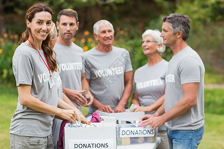 快乐的志愿家庭拿着捐赠箱团队男性团体道德志愿者晴天捐款女士女性闲暇图片