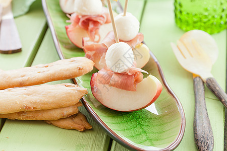 含有熏火腿的肾上腺素切片果味沙拉异国水果桃子火腿饼干绿色面包食谱背景图片