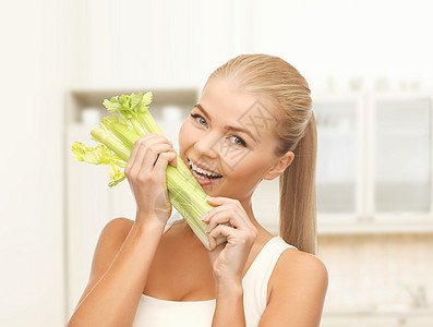 咬女人的切菜或绿色沙拉维生素营养素芹菜微笑饮食厨房生物减肥保健女孩图片