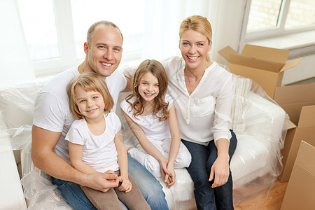 双亲和两个小女孩在新家里笑着母亲成人爸爸搬迁女士家庭父亲公寓父母纸板图片