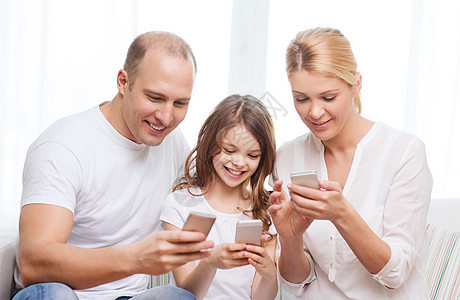 父母和家里有智能手机的小女孩的父母孩子青春期幸福父亲青少年互联网女儿上网童年爸爸图片