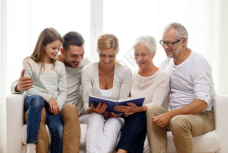 家里有书本或相册的幸福家庭沙发快乐女性母亲照片儿子长椅老年祖父孙子背景图片