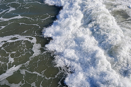 海滩上的波浪天线泡沫白色海浪海岸攻击背景图片