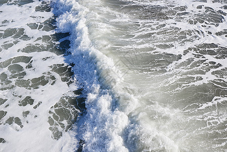 海滩上的波浪海浪天线海岸攻击泡沫白色背景图片