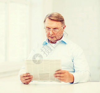 家庭阅读报纸上的老人成人读者时间祖父幸福闲暇男性老年退休微笑图片