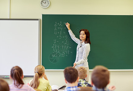 学生和教师在黑板上写字课堂数学男孩们房间学校小学生女孩们年轻人女学生算术图片