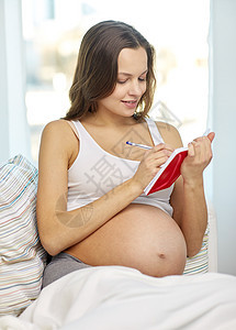 在家写笔记本的孕妇快乐怀孕妇女图片