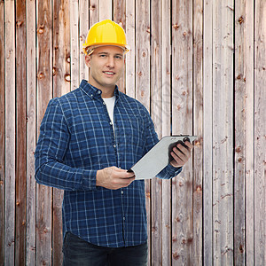 用剪贴板戴头盔的男性微笑建筑工男人工作栅栏建造职业黄色职员领班硬件维修图片