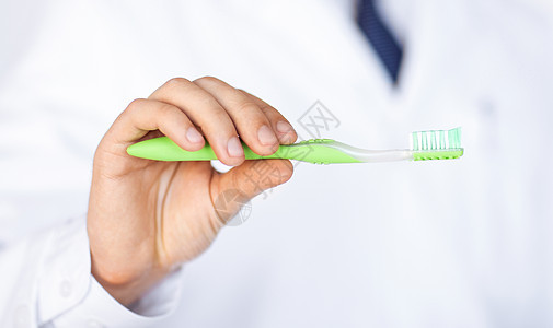 持有牙刷的牙医或口腔医生诊所疾病护理治疗假牙牙齿口腔科教育打扫药品图片