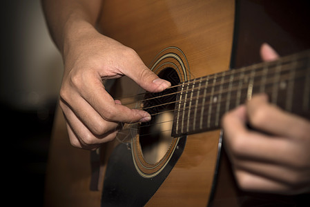 活生生的人弹吉他棕褐色岩石玩家指板白色记录旋律男人字符串手指图片