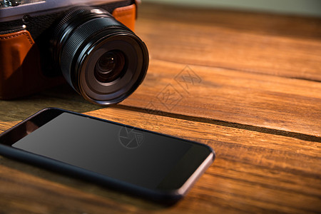 一个漂亮的棕色传统相机 下一个智能手机照片潮人木头摄影复古电话阴影技术复兴图片