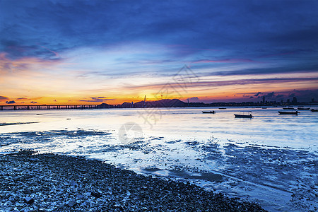 日落海岸 有一座连接对面的桥图片