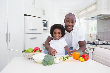 小男孩和爸爸一起做饭孩子健康饮食切菜板家庭生活微笑男性沙拉父亲厨房男人图片