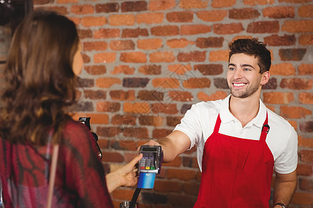散发针头终端的微笑服务员咖啡屋店铺男人顾客饮料女士食品雇主围裙支付图片