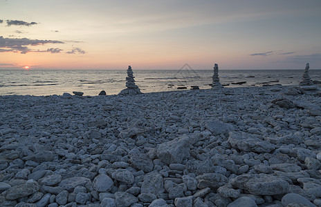 岩石在彼此间沉积天空支撑海洋鹅卵石太阳日落石头图片