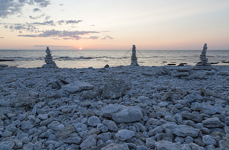 岩石在彼此间沉积海洋太阳日落鹅卵石天空支撑石头图片