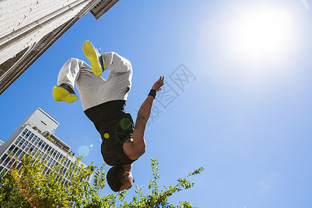空中建筑极端运动员在大楼前空中跳跃着极端运动员男人活动力量极限文化男性生活方式运动城市生活城市背景