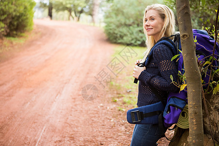 背包旅行在路边等待着微笑的女子徒步旅行者帮助女性活动农村娱乐女士登山杖荒野冒险潮人背景