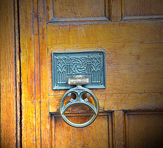 红色铜钉和光亮的黄铜制铜甲入口金属门把手城市建筑装饰品古董建筑学房子文化图片