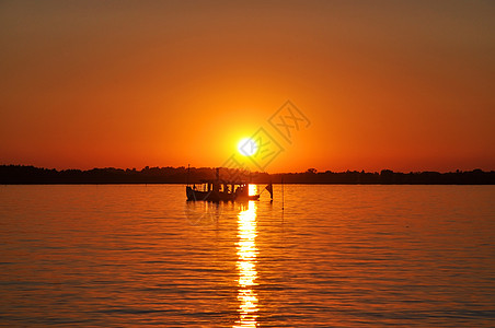 日落捕捞剪影太阳渔船海浪地平线运输钓鱼风景橙子日出背景图片