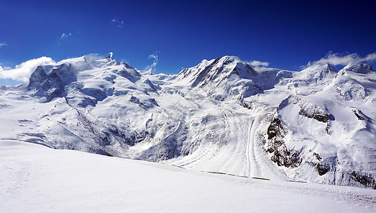山丘和蓝天空蓝色冰川场景晴天全景雪山旅行爬坡天蓝色滑雪图片