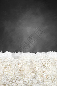 白色毛皮地毯和深灰漆黑的墙高清图片